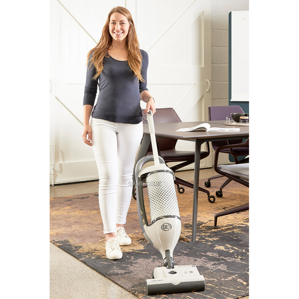 A woman using the SEBO DART 1 vacuum cleaner.